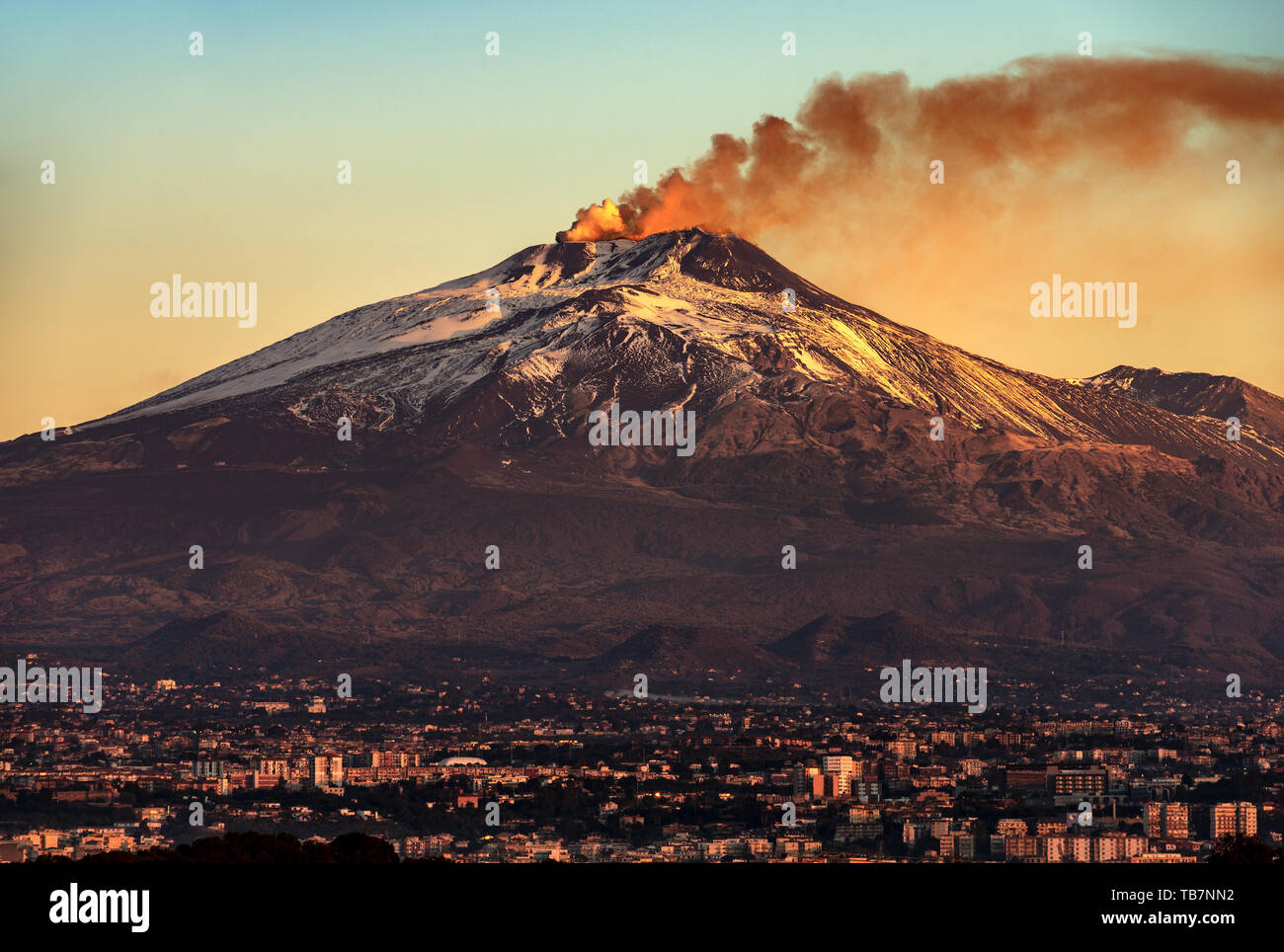 Mount Etna Volcano with smoke at dawn and the Catania city, Sicily