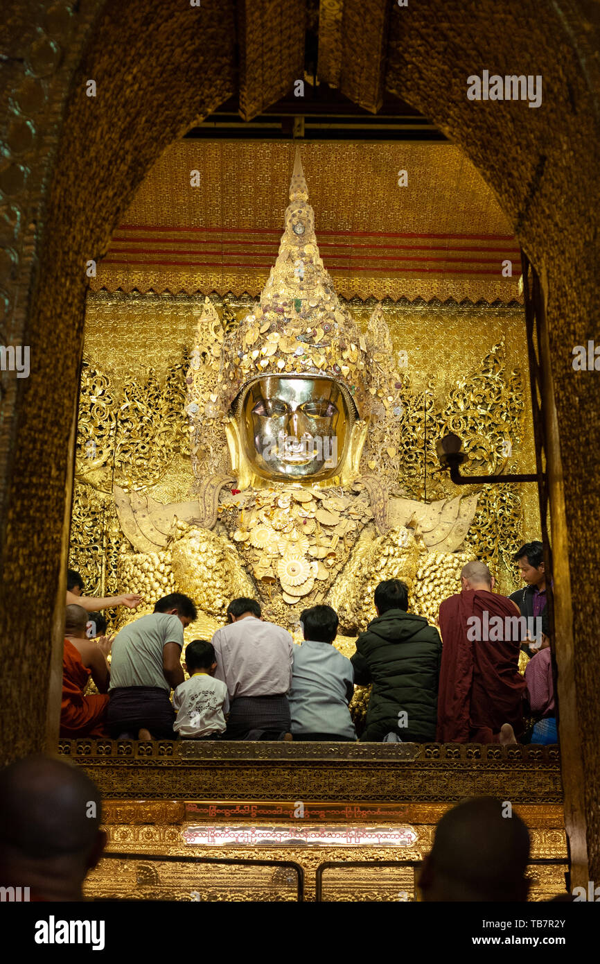 MANDALAY, MYANMAR JANUARY 25 The faithful apply squares of gold leaf