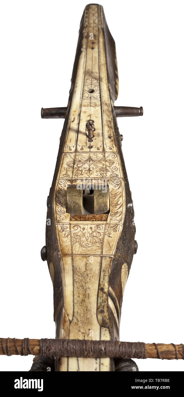A South German heavy crossbow (full size), circa 1580, Robust, iron prod (width 93 cm), double Breslau(?) marks on the inside. Older cord bridle with interlaced iron suspension ring, polychrome tassels and older repair of nailed leather. Tiller veneered with engraved horn and decorated with engraved bone inlays, partially added at the underside. Four-axle lock with older brass nut, lateral iron studs for the cranequin. Trigger guard broken off (enclosed). Length 77 cm. Impressive, heavy crossbow for shooting at a wooden bird. crossbow, crossbows,, Additional-Rights-Clearance-Info-Not-Available Stock Photo