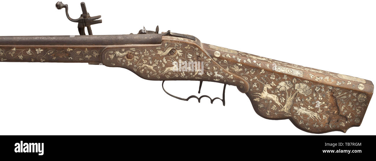 A wheellock rifle, historicism, assembled of older parts, Smooth barrel in 15 mm calibre with brass front sight and fixed rear sight. Iron wheellock (circa 1620, mechanism complete) with lock plate engraved with a hunting scene at a later date. Fruitwood full stock elaborately veneered with bone and decorated profusely with hunting and floral designs, bone nose. Iron trigger guard and wooden ramrod. Patinated iron parts, four larger bone inlays missing. Length 108 cm. shoulder arm, weapons, arms, weapon, arm, military, militaria, firearm, fire ar, Additional-Rights-Clearance-Info-Not-Available Stock Photo