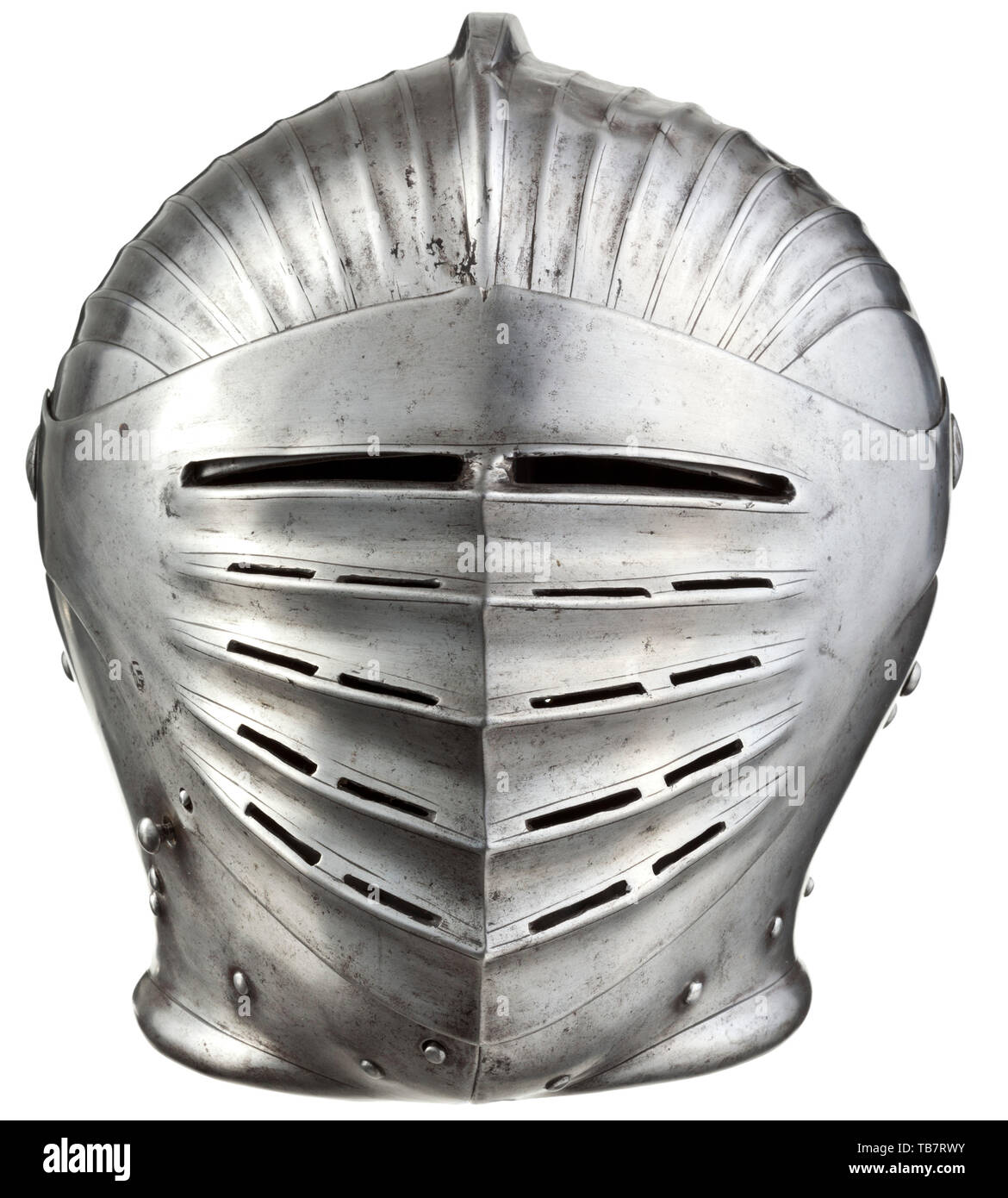 A well-formed South German Maximilian fluted armet of distinctive provenance, circa 1520, With strongly shaped broad rounded skull of one piece drawn up to an angular comb flattened over the top, embossed with bands each of eight shallow flutes over each side from nape to brow, the segmental ridges and the comb all accentuated by engraved lines, the base of the nape flanged for turning on the gorget, and the skull pierced for a crest and with eight pairs of lace-holes, fitted with a pair of hinged cheek-pieces shaped in continuation of the neck-f, Additional-Rights-Clearance-Info-Not-Available Stock Photo