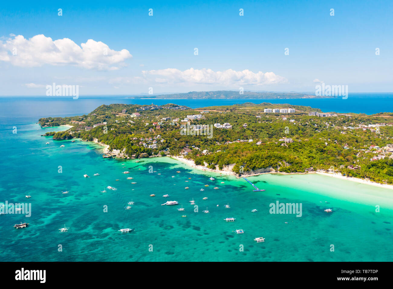 Tourist boats off the coast of the island of Boracay, Philippines, aerial view. Big island with hotels and a white beach. Seascape with a beautiful coast. Stock Photo