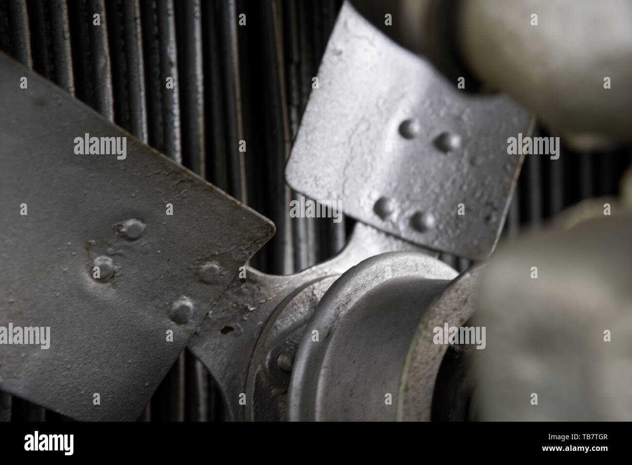 Vintage antique automotive tractor rusty fan blade and belt behind the