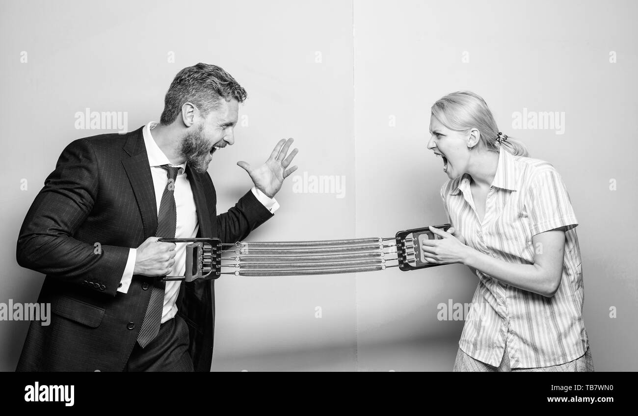 Gender equality and discrimination. Gender rivalry concept. Man and woman stretching expander opposite sides. Business rivalry guy and girl. Gender confrontation at workplace. Gender equal rights. Stock Photo