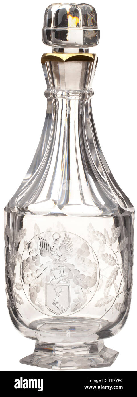 Hermann Göring - a large crystal carafe produced by Baccarat for his 50th birthday in 1943, Made of cut glass, the stopper in the shape of four acorns, the spout with a gold trim, the neck faceted, the carafe round-bellied and decorated with engraved oak leaves, a large helmeted Göring family coat of arms in a medallion in the centre, octagonal base. Height 32.5 cm. Extremely rare. Hermann Göring's 50th birthday on 12 January 1943 was the last major social event of the Third Reich. In vying for the Reich Marshal's favour, leading figures from the military, politics and indu, Editorial-Use-Only Stock Photo