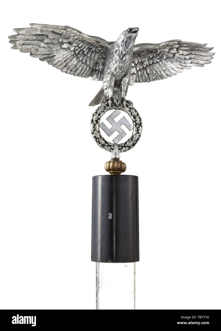 A large eagle for a Jingling Johnny, Wrought of polished aluminium. The eagle in relief with outspread wings, clutching the oak leaf wreath with a swastika in its talons. A flattened ball in non-ferrous metal screwed onto the bottom (part of the Jingling Johnny). On a matching black stone pedestal. A crack at the base of the left wing, showing signs of age. Wingspan ca. 55 cm, height without pedestal ca. 35 cm, total height ca. 56 cm. The large version of an extremely rare part of Wehrmacht equipment. historic, historical 20th century, Editorial-Use-Only Stock Photo