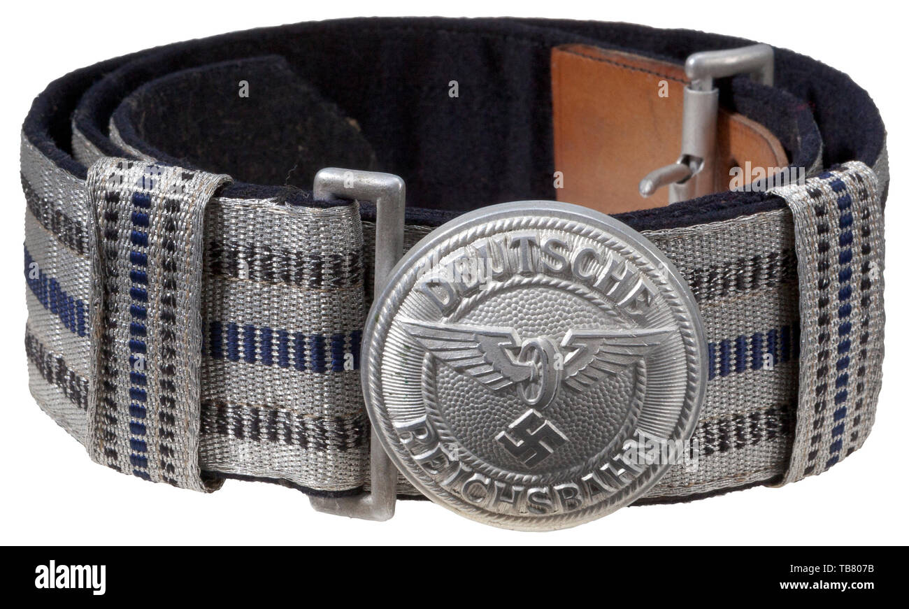 THE JOHN WAHL BELT AND BUCKLE COLLECTION, A Deutsche Reichsbahn Leader Brocade Belt and Buckle, Stamped aluminium 50 mm diameter buckle, reverse stamped with Assmann manufacturer's logo 'A' and 'DRGM'. 45 mm navy-blue wool backed aluminium/silver woven brocade with two navy-blue stripes and one blue centre stripe. Complete with two sliding, vertical 22 mm keepers of the same pattern. Tan leather size adjustment tongue complete with aluminium catch. Length approx. 120 cm., Additional-Rights-Clearance-Info-Not-Available Stock Photo