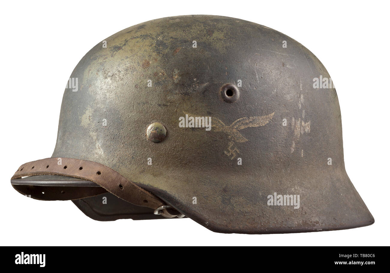 A steel helmet M 40 for members of Luftwaffe field divisions, The interior of the skull with maker's mark 'Q64' (Quist, Esslingen), green-toned camouflage paint covering the Luftwaffe-grey paint, the Luftwaffe eagle clearly visible. Complete with inner liner and chinstrap. Very rare camouflage. historic, historical 20th century, Editorial-Use-Only Stock Photo