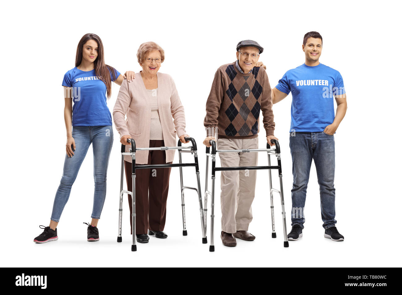 Full length portrait of a young man and woman volunteering and helping seniors with walkers isolated on white background Stock Photo