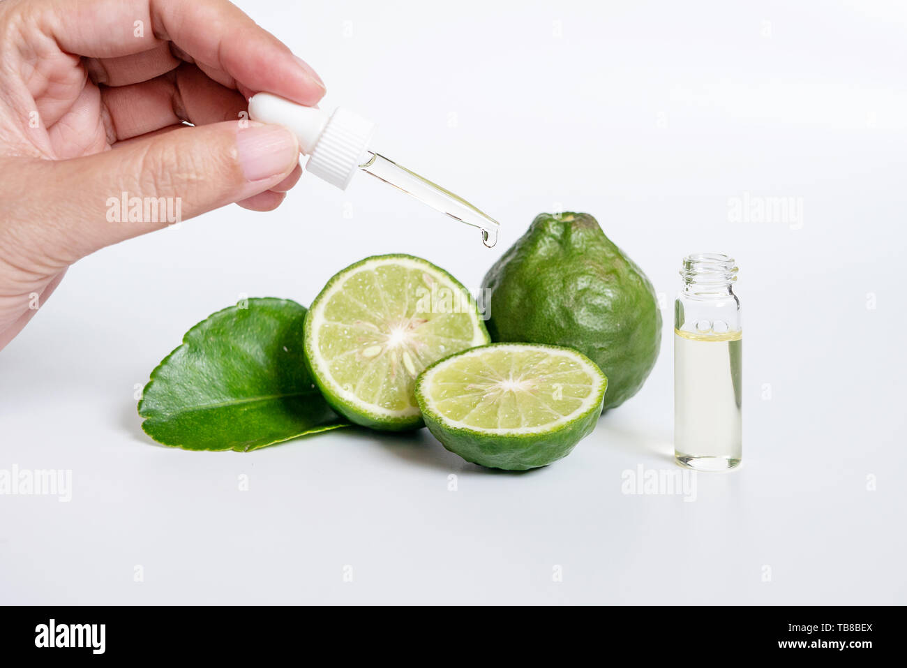 bergamot serum, organic products made from natural concept. woman hand holding glass dropper for dermatologist testing decorate with slide kaffir lime Stock Photo