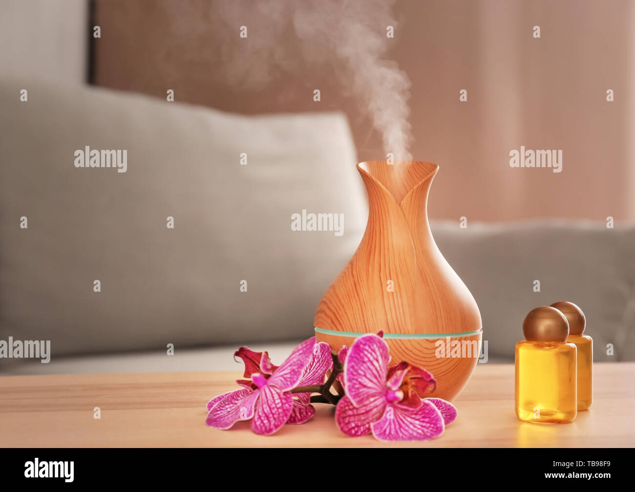 Aroma oil diffuser with bottles on table in room Stock Photo Alamy