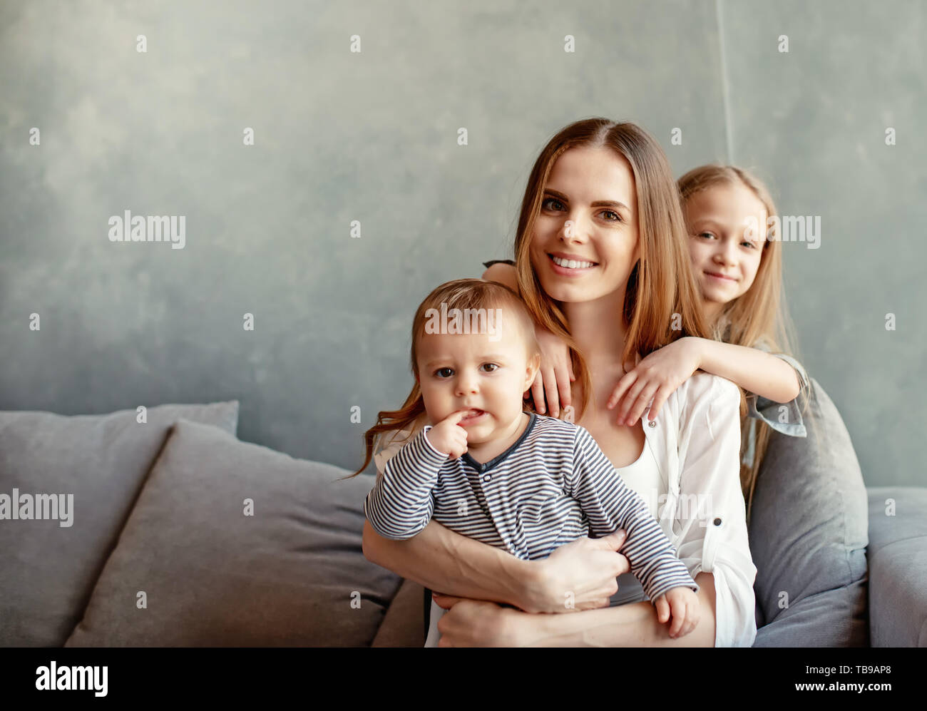 Happy young mother with her children at home Stock Photo