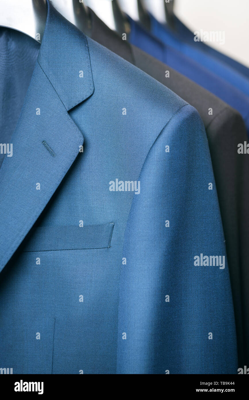 close up luxurious style gentlemen suit row, hanging in a closet . Stock Photo