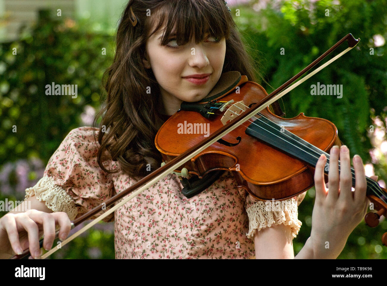 A girl plays the violin in the gardens of the Amzi Love Home in Columbus, Mississippi, April 17, 2010. Stock Photo