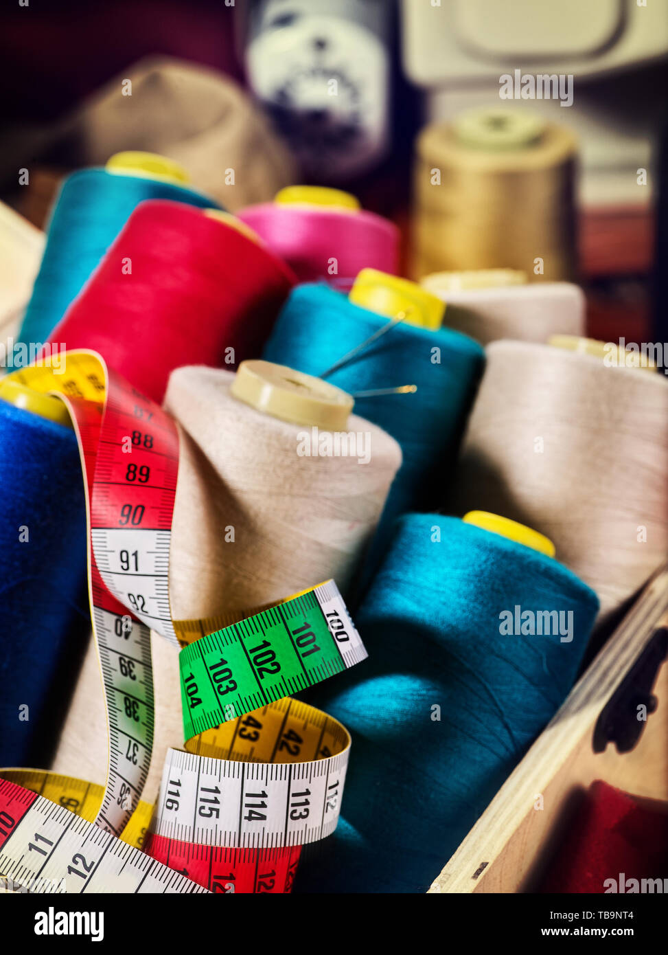 Coil threads for overlock and measuring tape on serger background Stock Photo