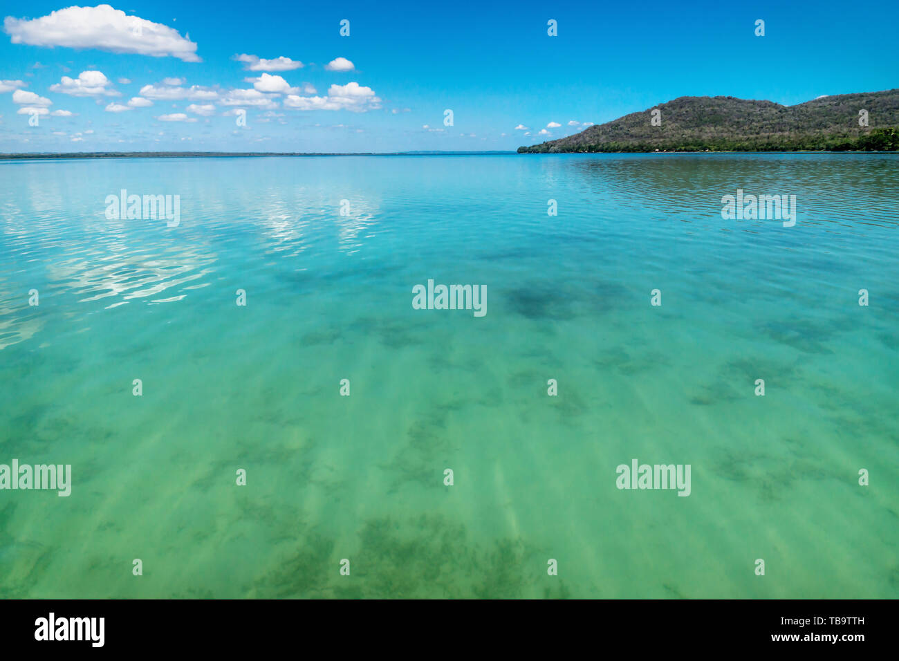View on Lago Peten Itza with crododile shaped hill and sunny cloud sky, El Remate, Guatemala Stock Photo