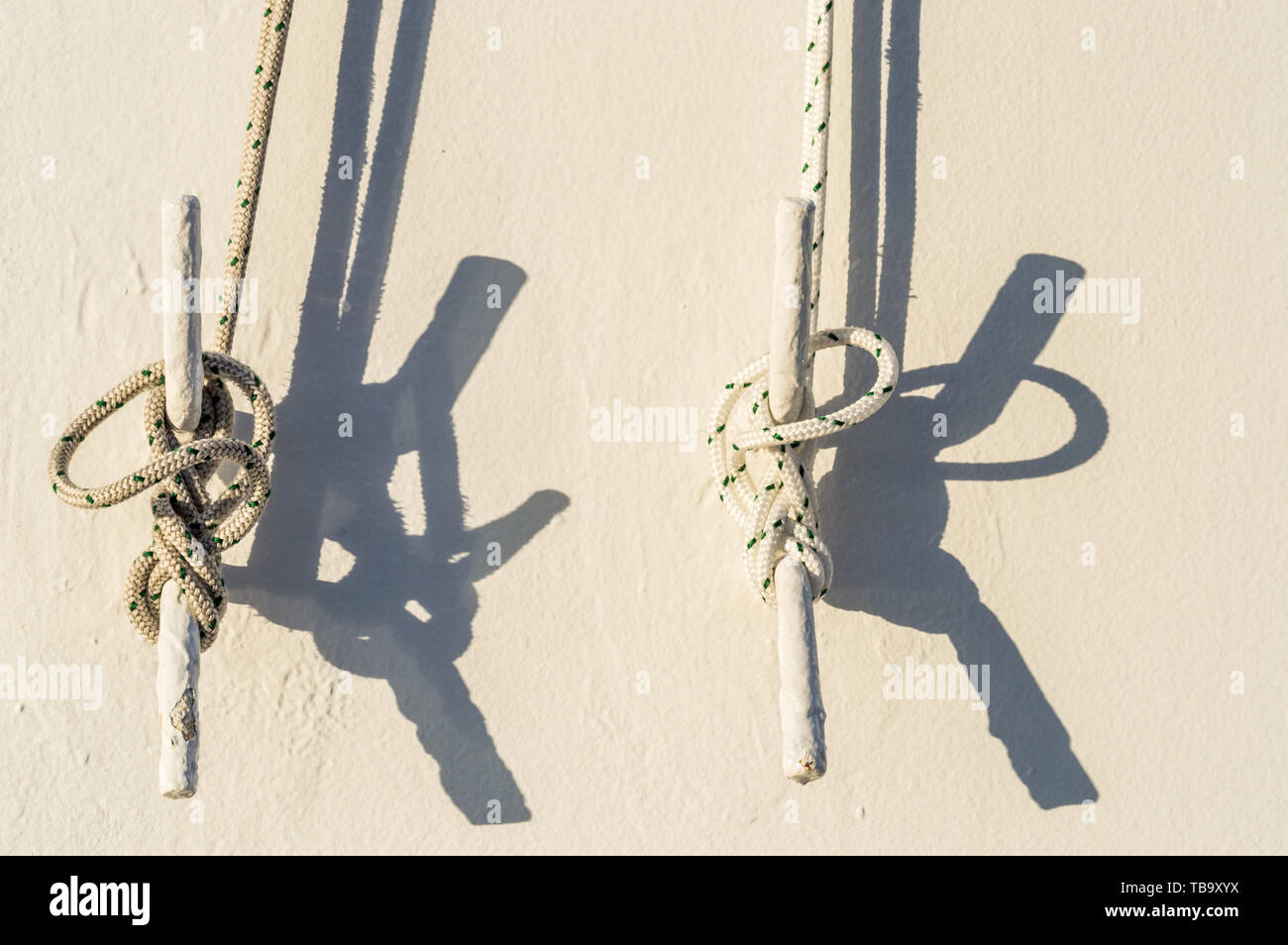 Two Nautical Ropes Tied With Marine Knots To Metal Cleats On White Exterior Wall Of Cruise Ship In Morning Sunlight Stock Photo Alamy
