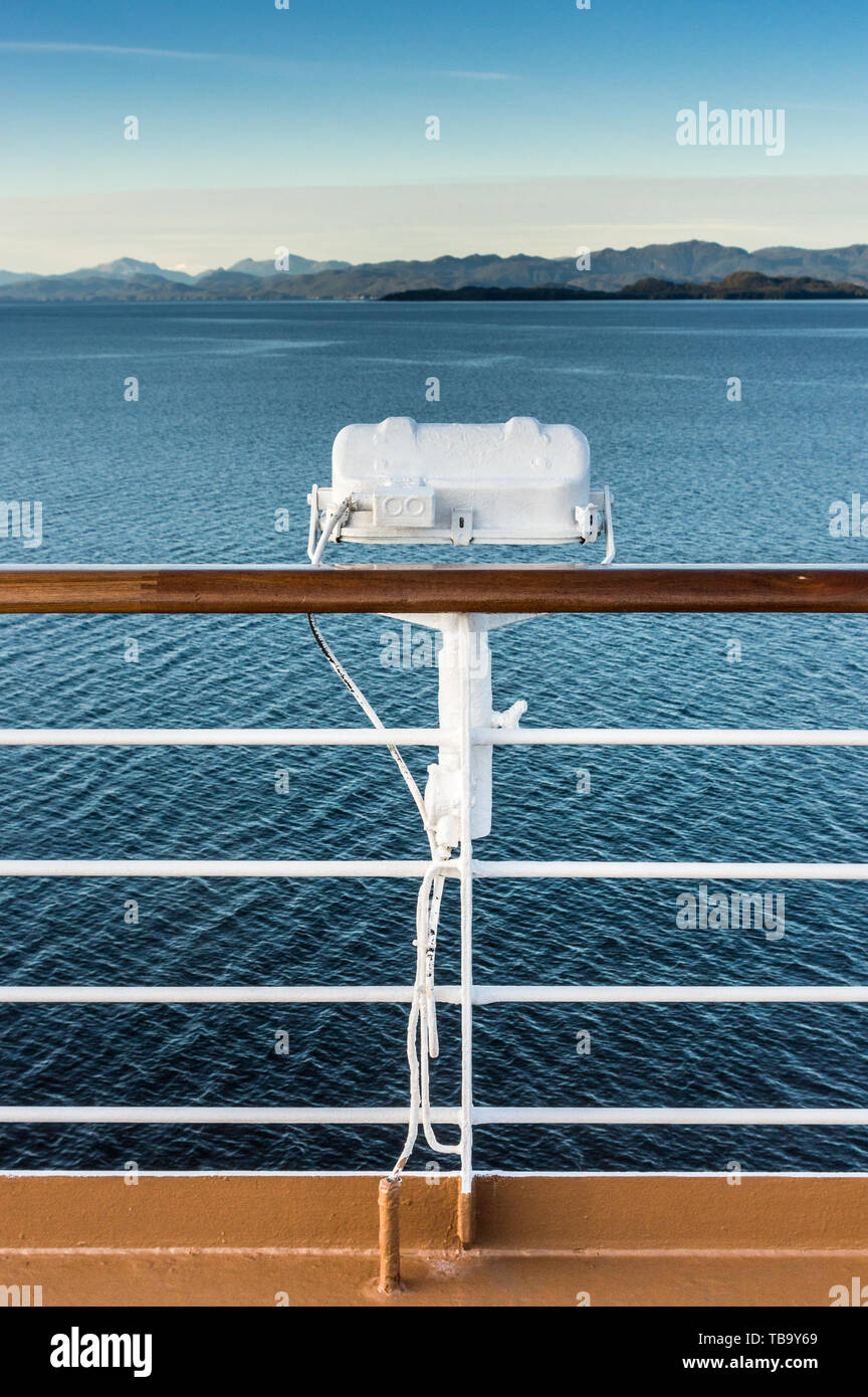 White metal marine exterior light fixture on railing of cruise ship, early morning, Alaska Inside Passage route. Stock Photo