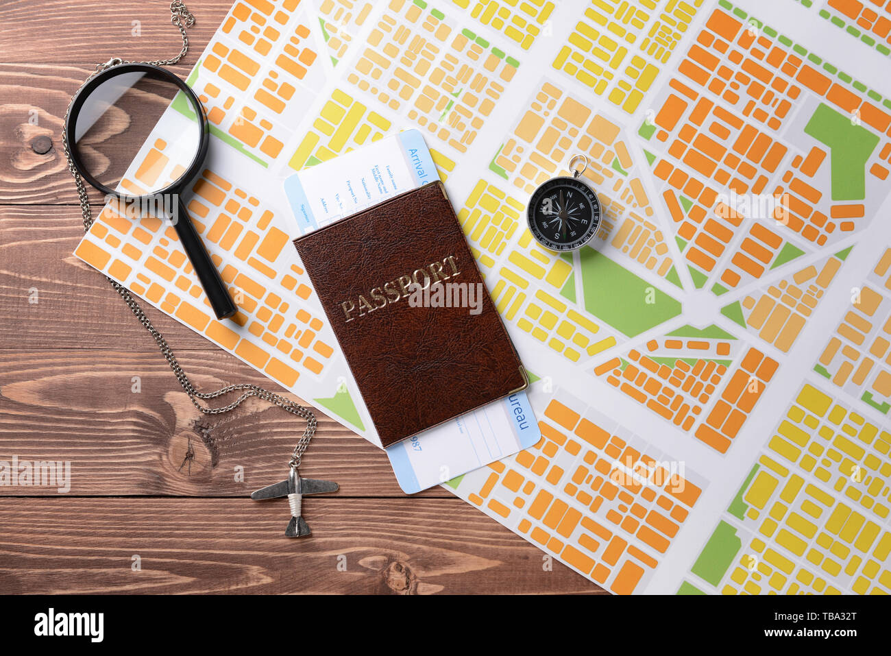 Map with passport, compass and magnifier on wooden table Stock Photo