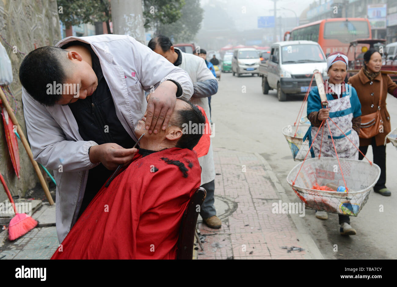 Getting a shave by a street barber in Kaili, Guizhou, China Stock Photo ...