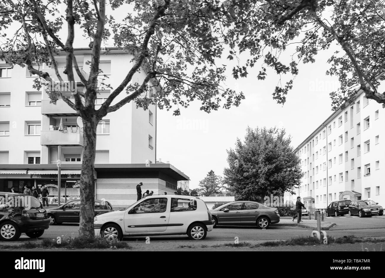 Strasbourg, France - May 3, 2018: Cite de l'Ill HLM Habitation a loyer modere rent-controlled housing French buildings with young group of arab boys - black and white Stock Photo