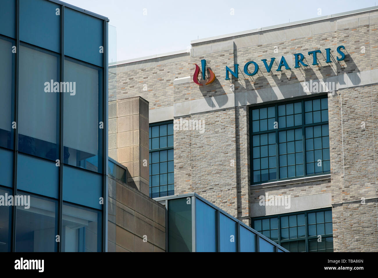 A logo sign outside of a facility occupied by Novartis International in Cambridge, Massachusetts on April 29, 2019. Stock Photo