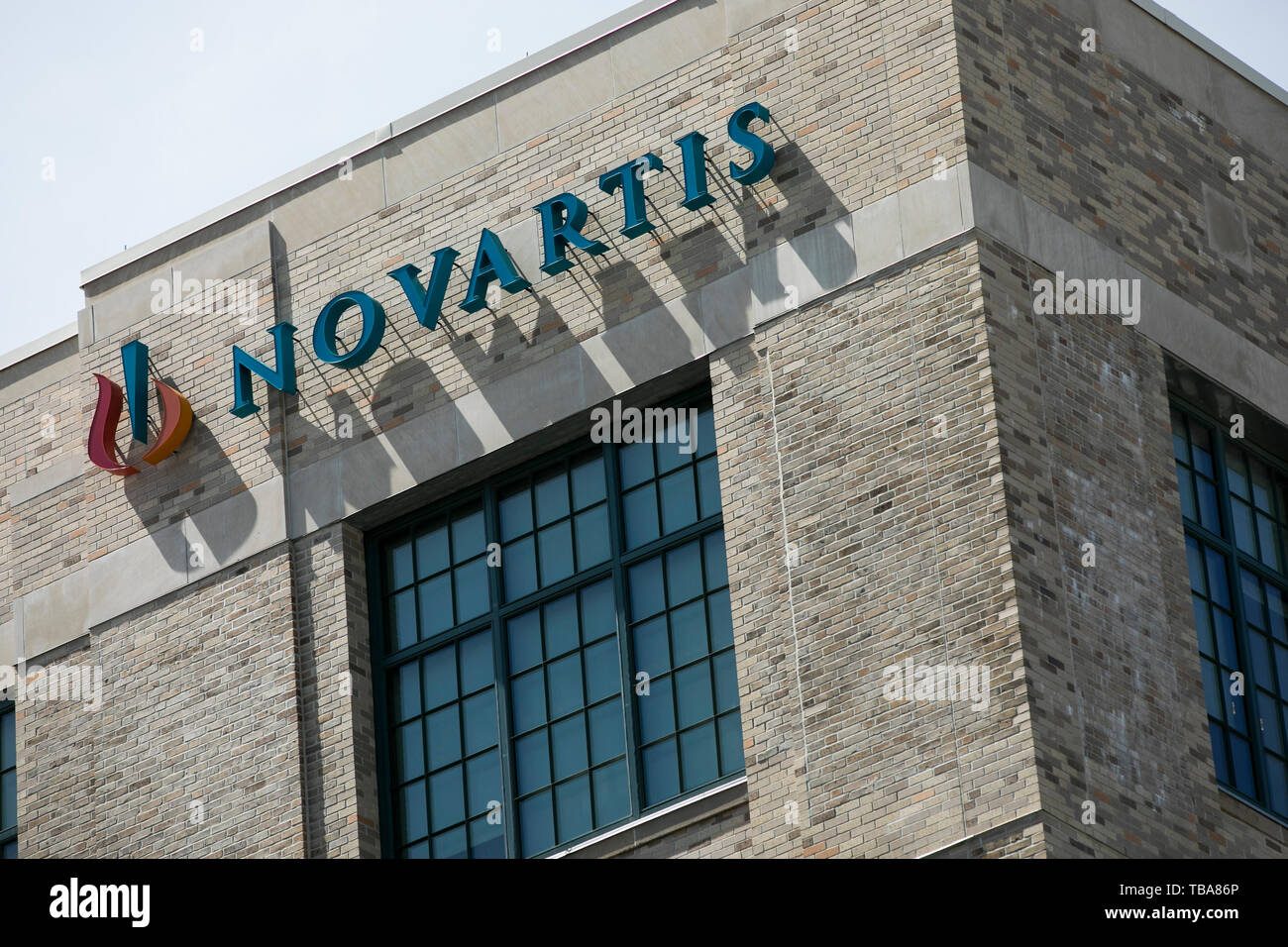 A logo sign outside of a facility occupied by Novartis International in Cambridge, Massachusetts on April 29, 2019. Stock Photo
