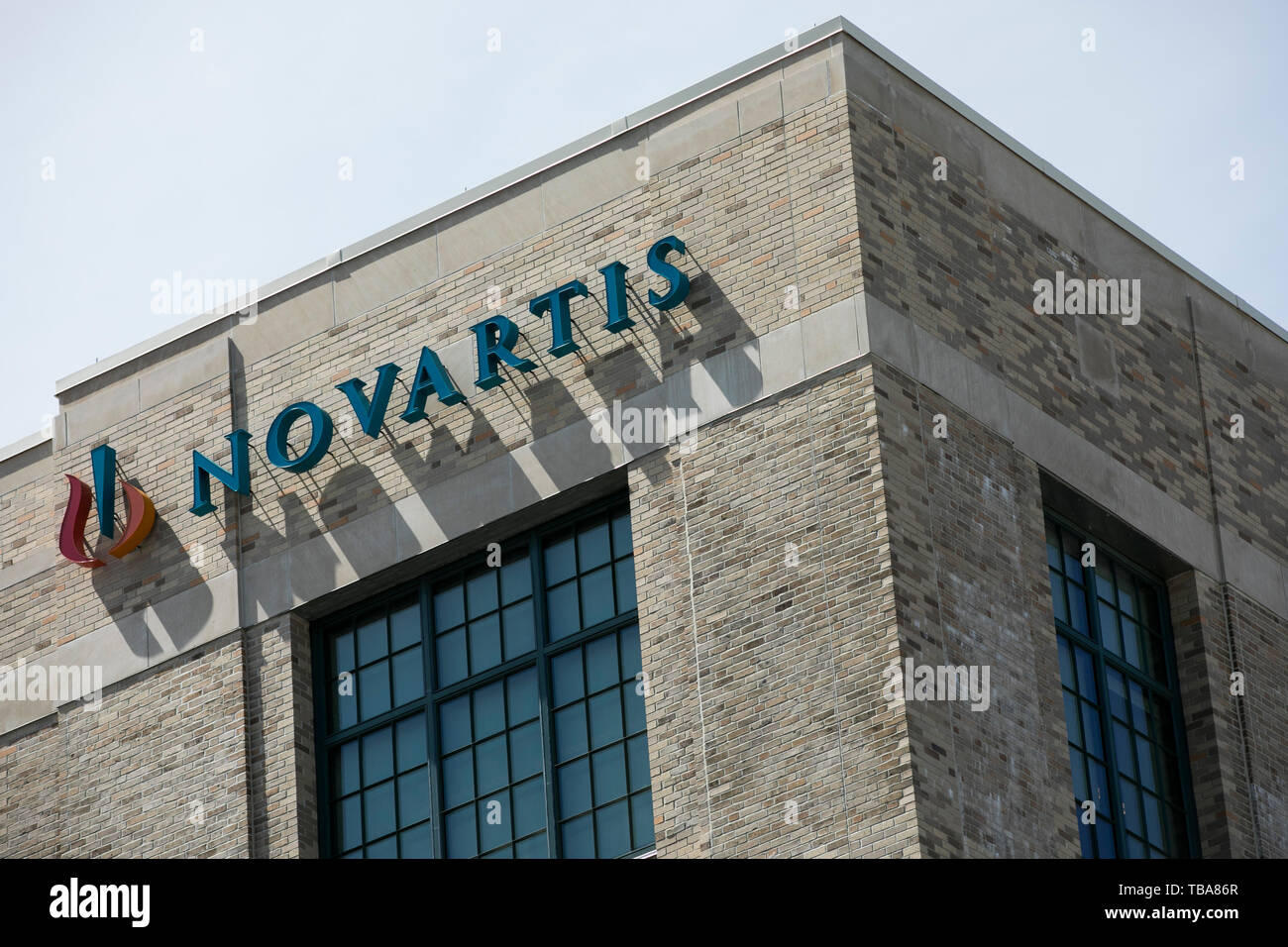 A logo sign outside of a facility occupied by Novartis International in Cambridge, Massachusetts on April 29, 2019. Stock Photo