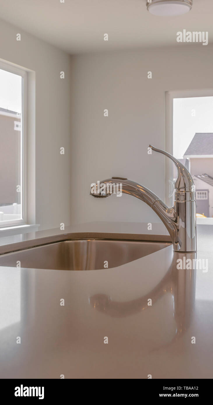 Vertical Interior of a kitchen with sink and faucet on the glossy ...