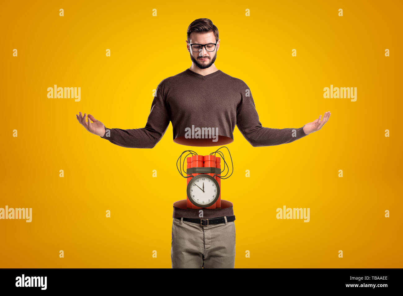 Young man in casual clothes cut in half with big red dynamite stick time bomb inside on yellow background Stock Photo