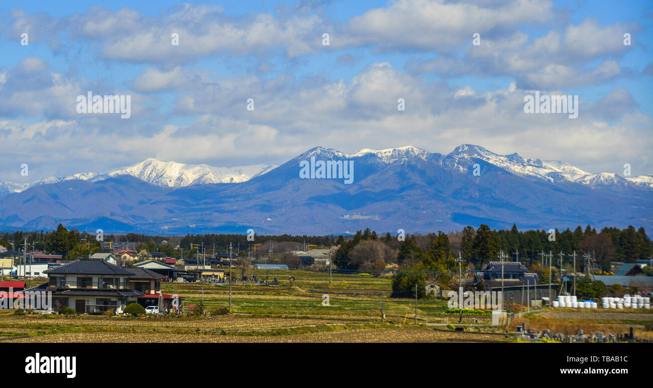 Fukushima, Japan - Apr 15, 2019. Small town with snow mountain in Fukushima, Japan. Fukushima is the place where the nuclear disaster occurred in 2011 Stock Photo