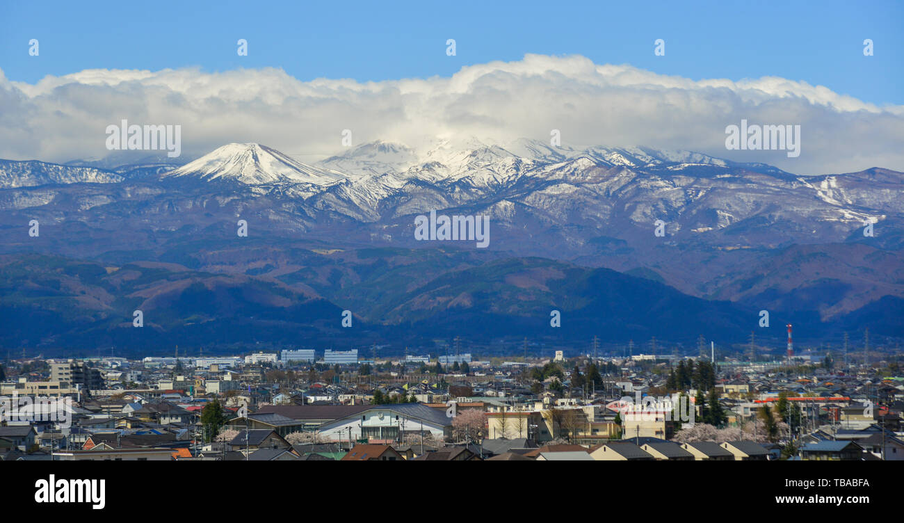 Fukushima, Japan - Apr 15, 2019. Cityscape with snow mountain in Fukushima, Japan. Fukushima is the place where the nuclear disaster occurred in 2011. Stock Photo