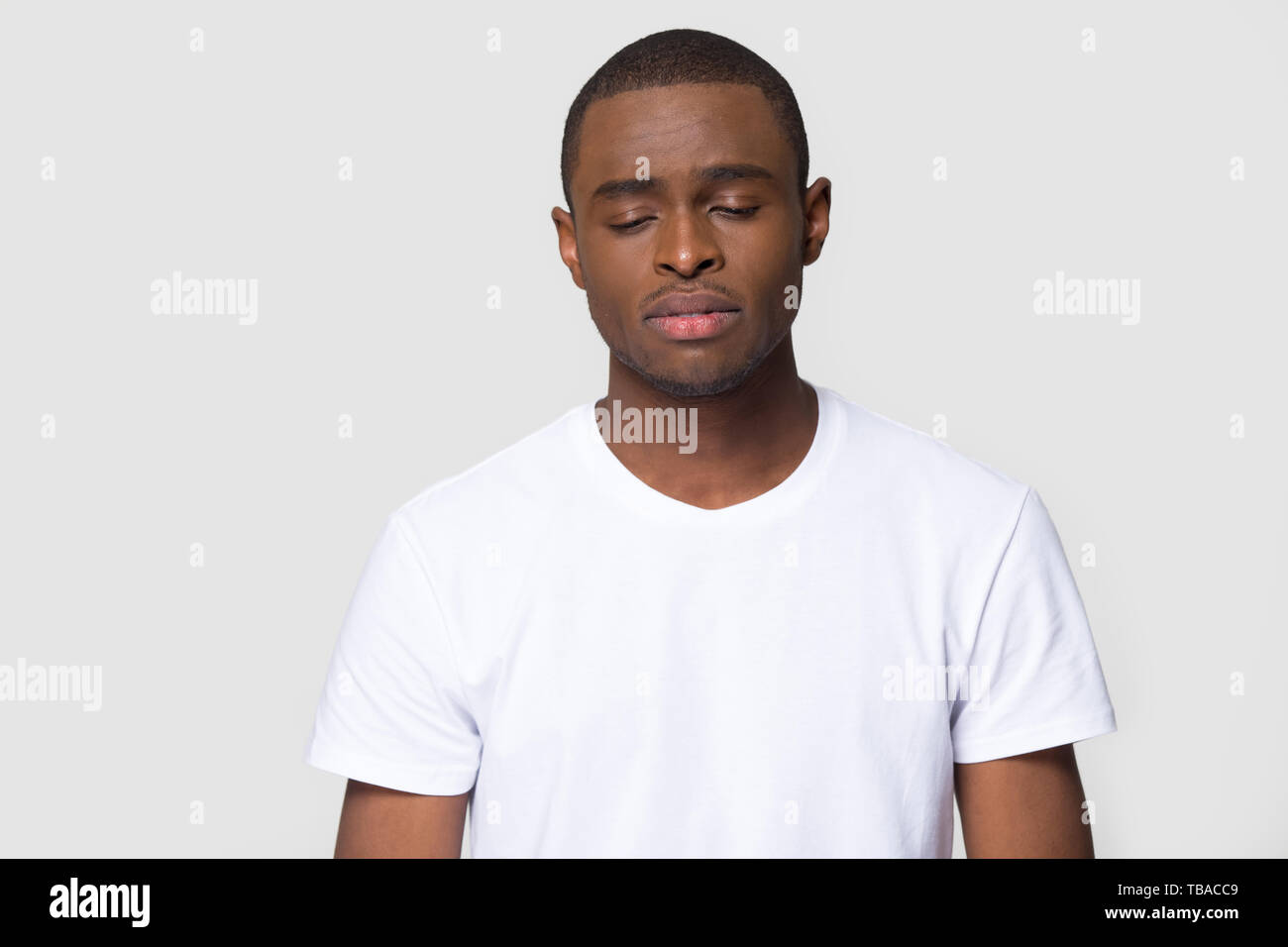 Head shot sad african male studio portrait on grey background Stock Photo