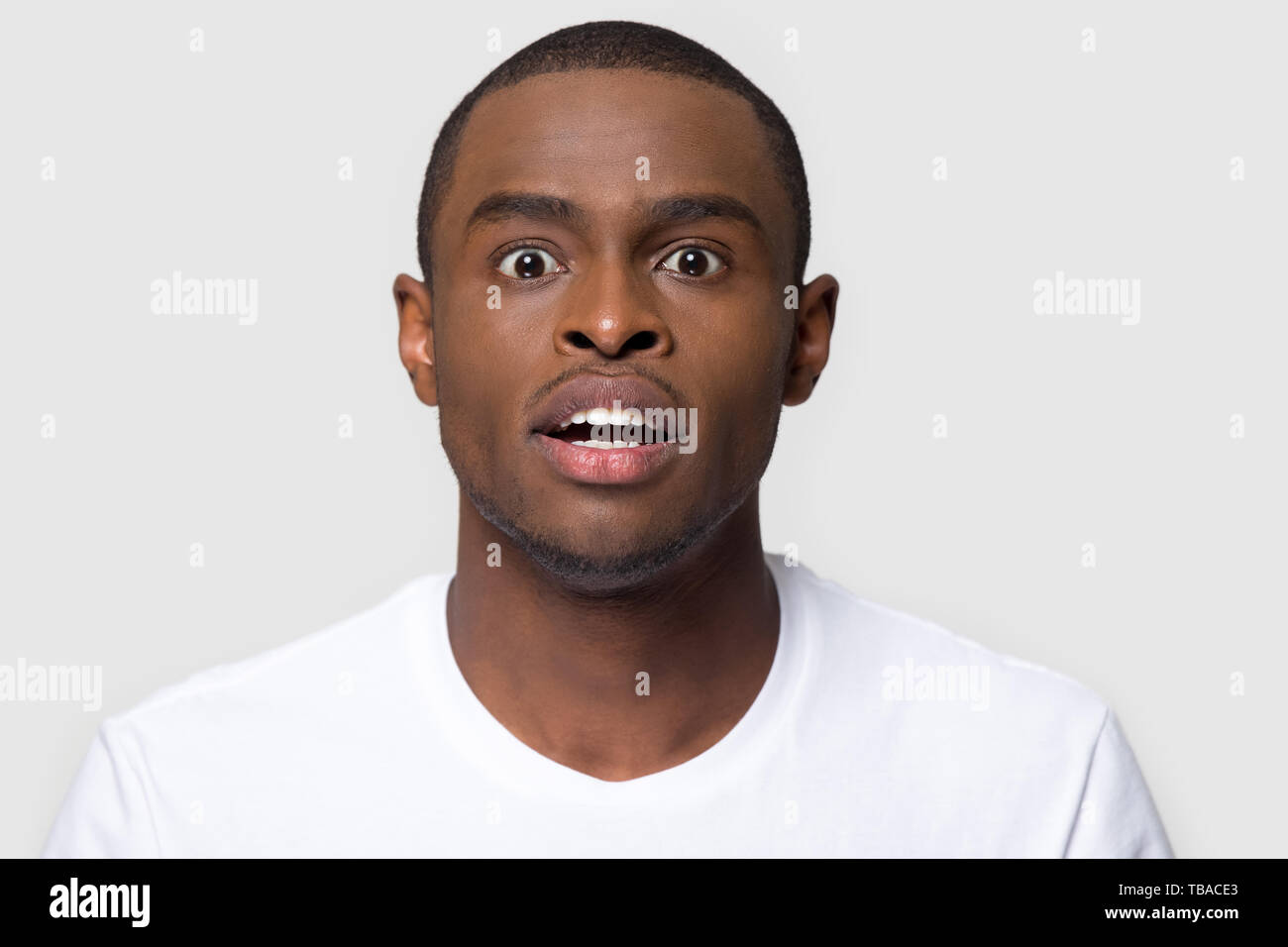Portrait african man makes big eyes feels amazed studio shot Stock Photo