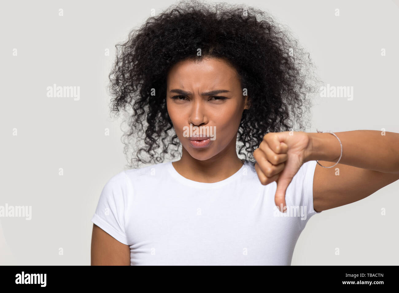 Unsatisfied african woman showing thumb down disapproval gesture Stock Photo