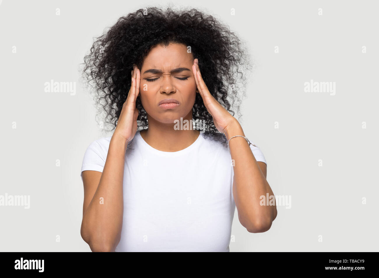 Headshot portrait stressed woman touching temples suffering from