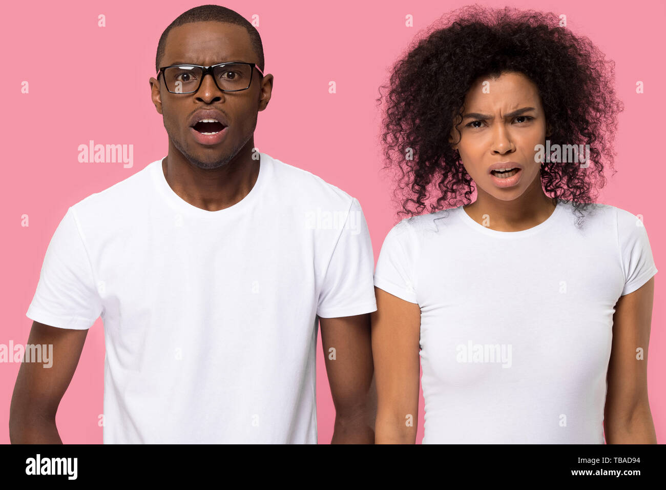 Shocked african couple looking at camera posing in studio Stock Photo