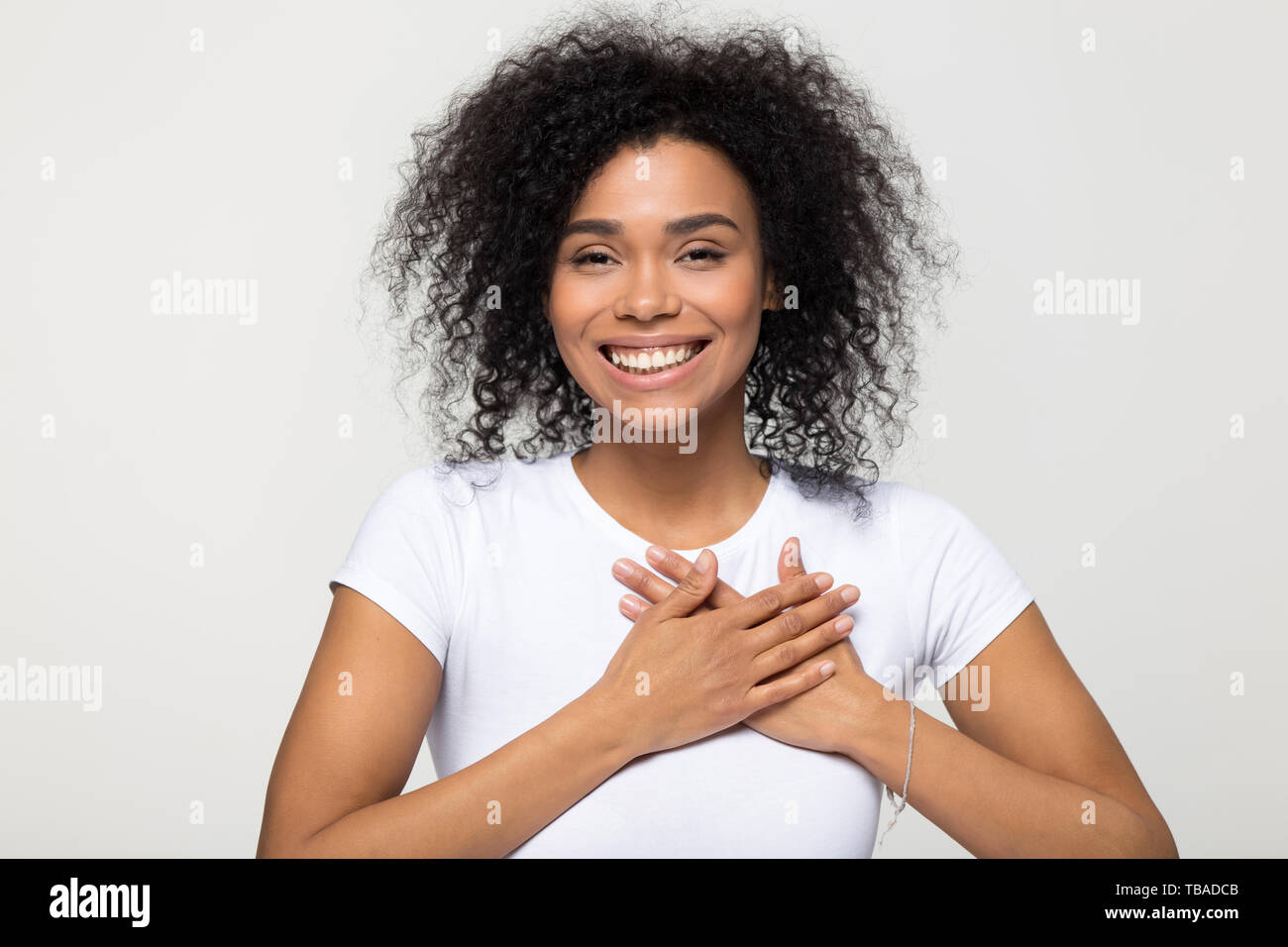 Headshot portrait american woman holding hand on heart feels gratitude Stock Photo