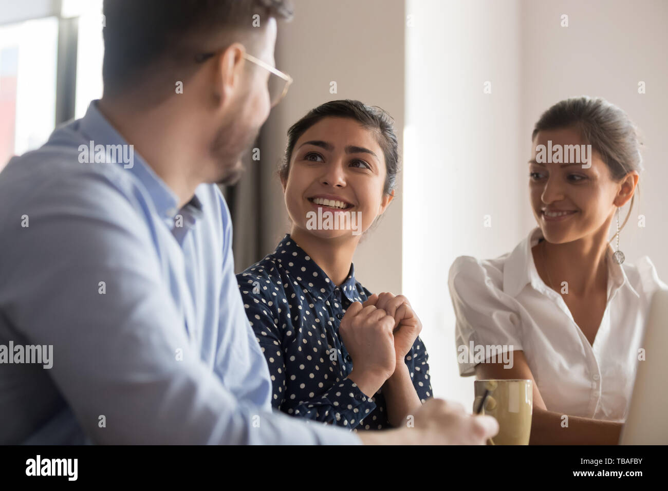 Smiling diverse colleagues talk discussing ideas together Stock Photo