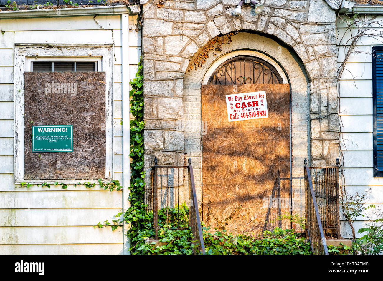 Atlanta, USA - April 21, 2018: Old abandoned house in Georgia with entrance and notice sign warning and company buying for cash and number Stock Photo