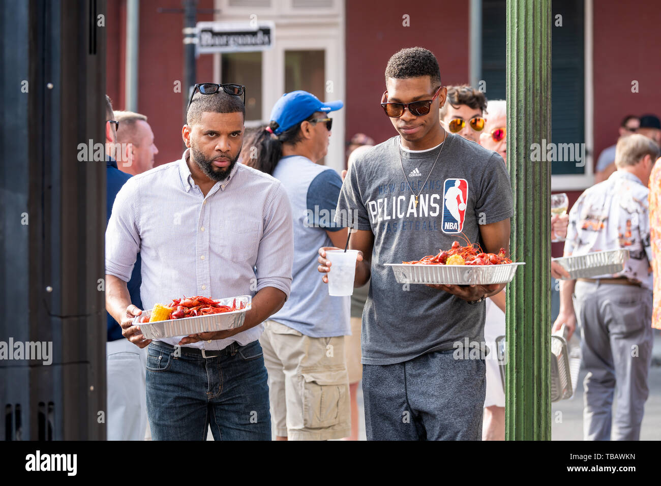 New Orleans, USA - April 23, 2018: Old town in Louisiana famous city with people by 700 club restaurant eating seafood lobsters holding trays Stock Photo