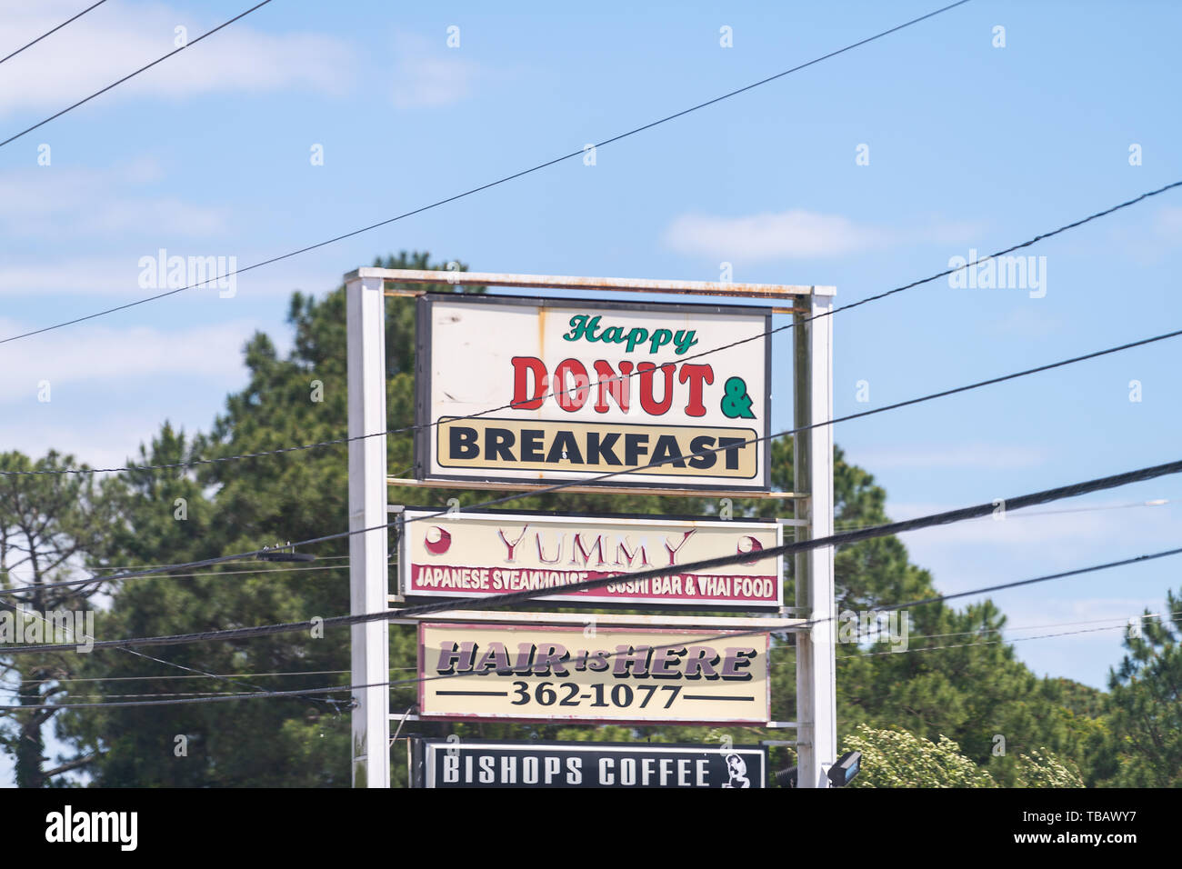Esther, USA - April 24, 2018: Road sign for restaurants, cafe coffee house food for Happy Donut breakfast, yummy Japanese steakhouse, sushi var and co Stock Photo