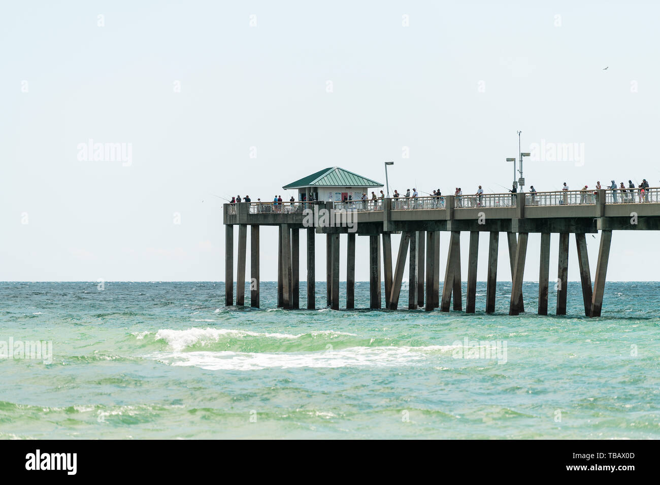 Fort Walton Beach, USA - April 24, 2081: Closeup of Okaloosa Island fishing pier in Florida in Panhandle Gulf of Mexico during sunny day with waves an Stock Photo
