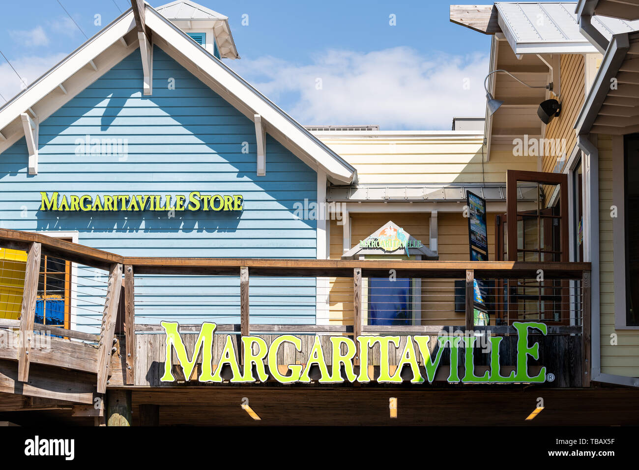 Destin, USA - April 24, 2018: Sign for Margaritaville bar restaurant building entrance with parrot and blue sky in Harborwalk Village, Florida Panhand Stock Photo
