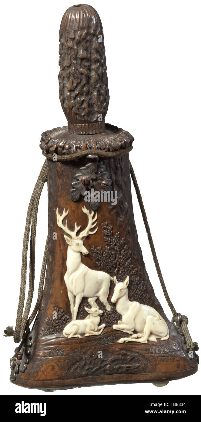 A Thuringian carved staghorn powder flask, circa 1830 Staghorn body with finely carved depiction of an impressive stag with hind and fawn on the front side. The reverse side with natural surface. The bottom and the cover plate made from staghorn, the spout with unscrewable lid that, at the same time, serves as a powder gauge. The closure button is missing. Silver suspension loops shaped like oak leaves with attached carrying cord. Length 17.5 cm. The style and the quality of the carving suggest an ascription to the carver Leberecht Schulz or his , Additional-Rights-Clearance-Info-Not-Available Stock Photo