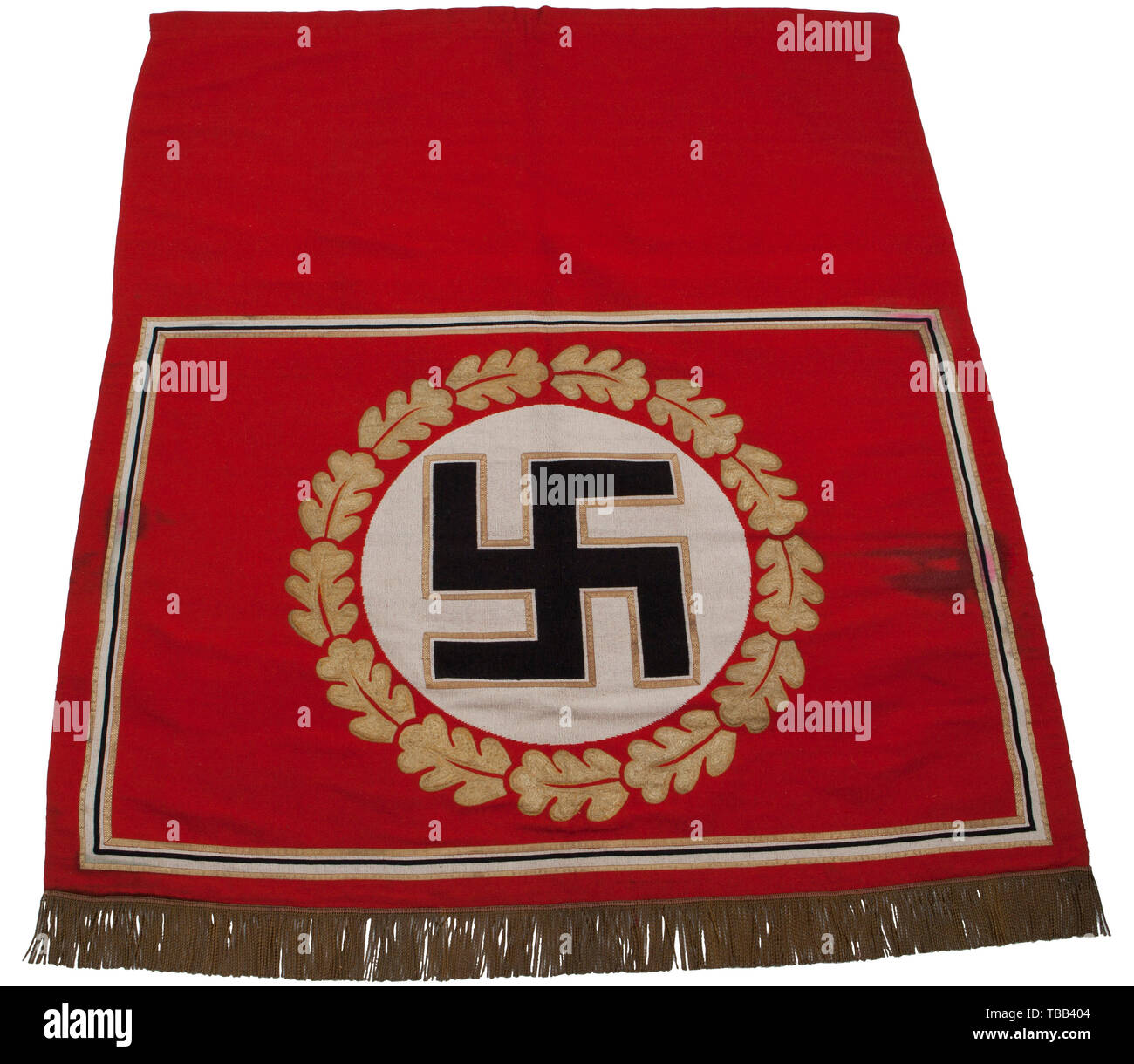 A Reich Chancellery tapestry From the New Reich's Chancellery in Berlin, heavy cotton construction, some soiling. Red field, with black-white border and gold edging. In centre, white disk with black swastika with gold trim, surrounded by gold-embroidered oak leaf wreath. Finished with gold fringe. Reverse covered in red cotton with tag embroidered 'RZM NSDAP der Obergebietsführer SA'. Upper edge with broad hem, inside a sleeve for wall hanging rod. Size 195 x 220 cm. See: Lt. Col. Thomas N. Johnson 'World War II German War Booty' Columbia 1982, p. 56 et seq. with illustrati, Editorial-Use-Only Stock Photo