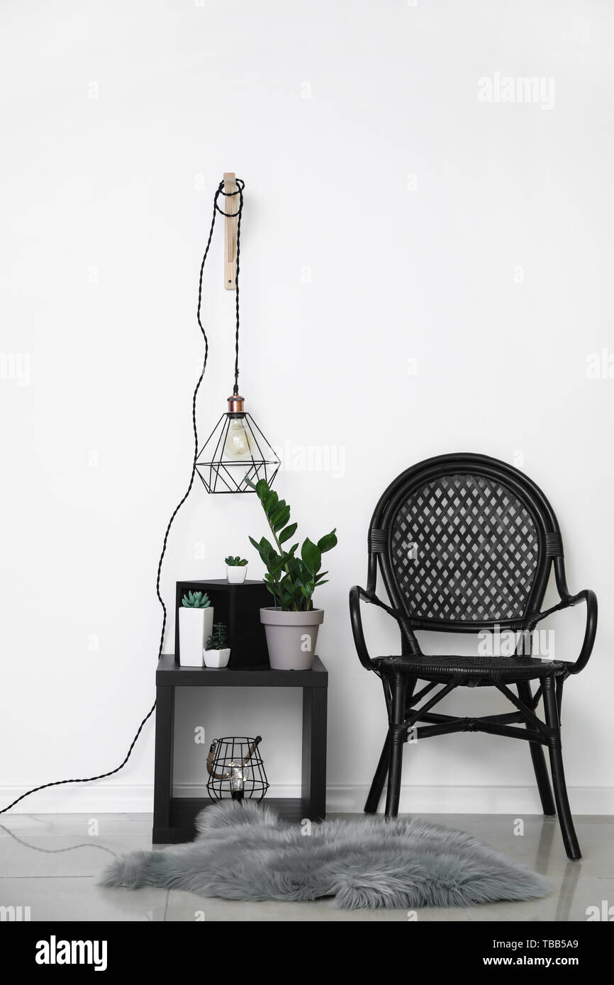 Wicker Chair With Plants In Pots And New Lamp Near White