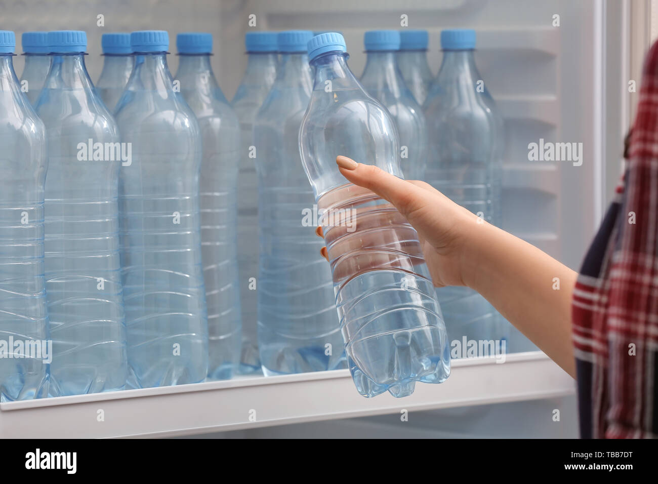 https://c8.alamy.com/comp/TBB7DT/woman-taking-bottle-of-water-from-fridge-in-shop-TBB7DT.jpg