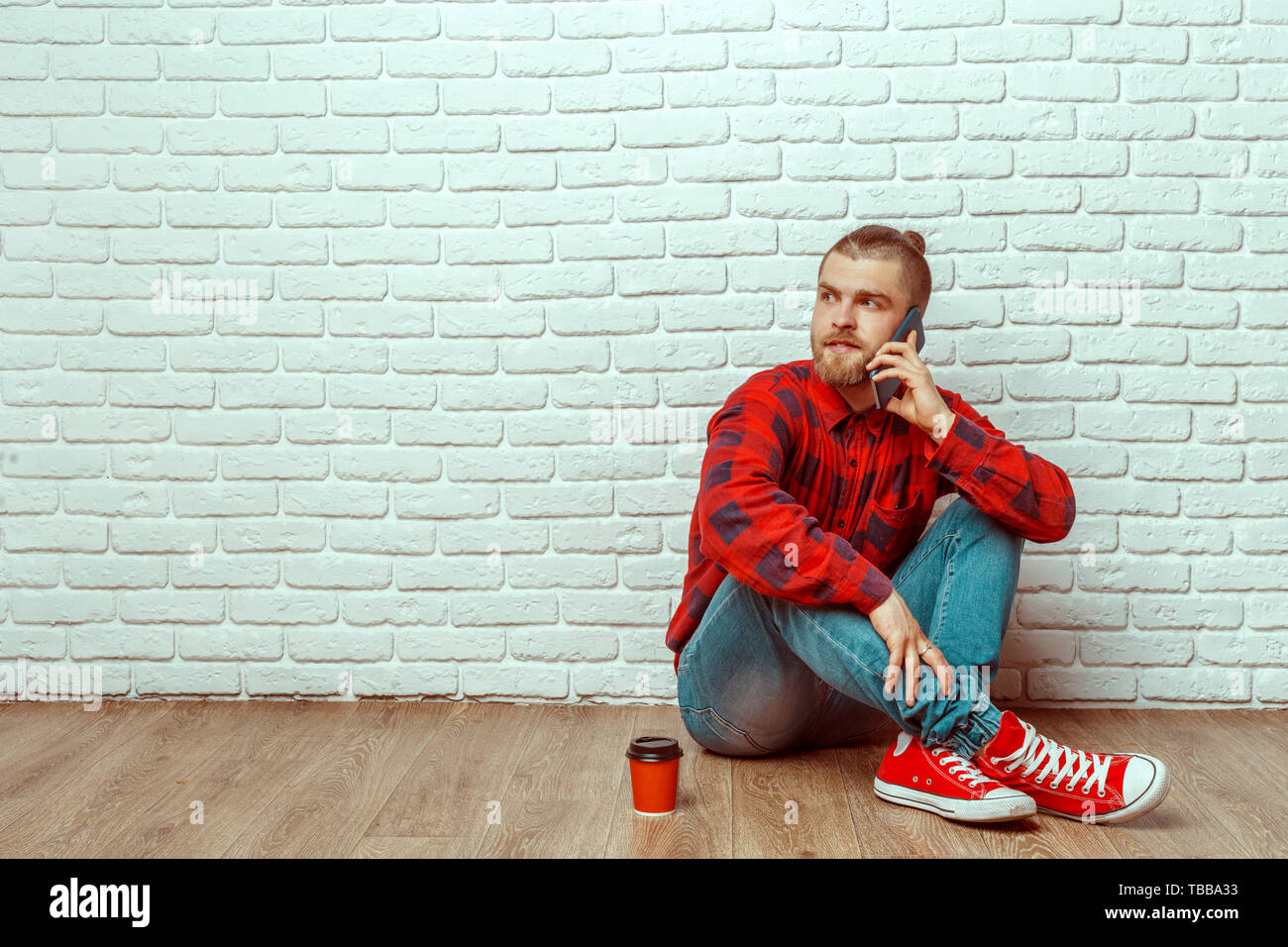 Happy casual man sitting on the floor Stock Photo - Alamy