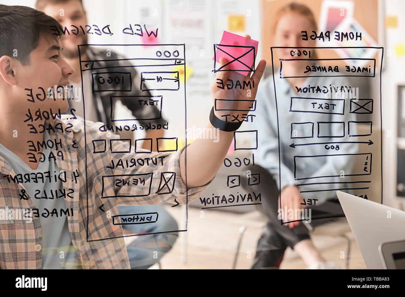 IT designers discussing project, view through transparent board Stock Photo